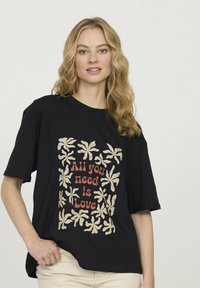 T-shirt en coton noir avec un motif floral et le texte « Tout ce dont vous avez besoin, c'est d'amour » dans des couleurs contrastées ; coupe décontractée et manches courtes.