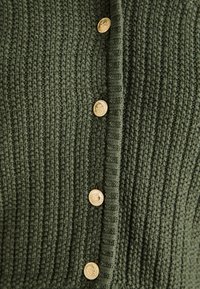 Pletený zelený cardigan s textúrovaným vzorom, vertikálnym žebrovaním a zlatými gombíkmi s dekoratívnymi akcentami.