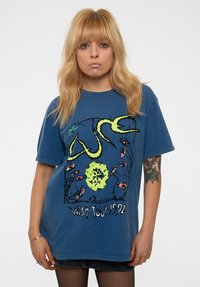 Blue cotton oversized t-shirt featuring a graphic print with black and green elements, text reading "Wish Tour 1992," and short sleeves.