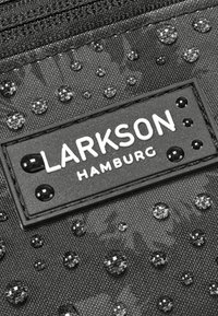 Čierna látková taška s textúrovaným povrchom a jasnými kvapkami, na ktorej je čierna nálepka s nápisom "LARKSON HAMBURG" bielymi písmenami.