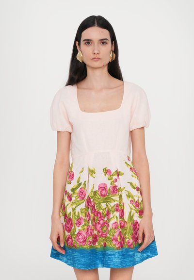 Robe fleurie avec un décolleté carré, de courtes manches bouffantes, un haut rose et une jupe ornée de vives roses roses et de feuilles vertes sur un ourlet bleu.