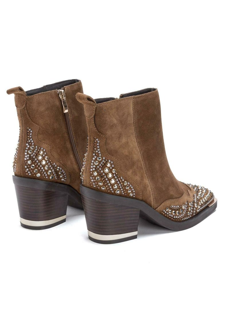 Brązowe zamszowe botki za kostkę ozdobione cyrkoniami, z okrągłym noskiem i obcasem w kształcie bloku. Posiadają boczny zamek błyskawiczny i fakturowane akcenty.