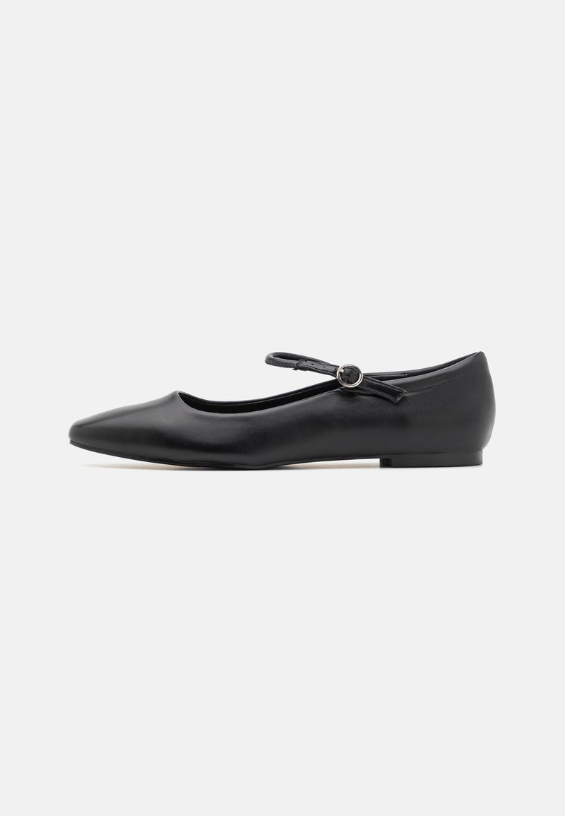 Ballerines synthétiques noires à bout pointu, avec une fine bride de cheville munie d'une boucle circulaire. Semelle plate et texture lisse.