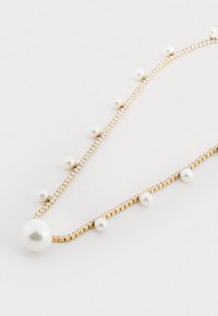 Collana d'oro con sezioni alternate di piccole perle e cristalli scintillanti, caratterizzata da una grande perla centrale e un design elegante e raffinato.
