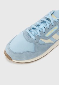 Lyseblå sneakers, der kombinerer ruskind og mesh-materialer, med tonede snørebånd og tre side-striber i off-white.