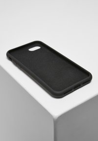 Crna futrola za pametni telefon s mat završetkom, mekom unutarnjom teksturom, izrezima za tipke i slim, elegantnim profilom.