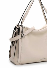 Sac à main en cuir beige texturé avec des accents noirs, deux poignées et une bandoulière amovible. Comprend une fermeture zippée et un détail en chaîne.