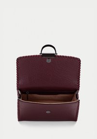 Burgundy läderhandväska med en strukturerad form, topphandtag och sydda kanter. Inredningen har en flerficksficka och ett rymligt huvudfack.