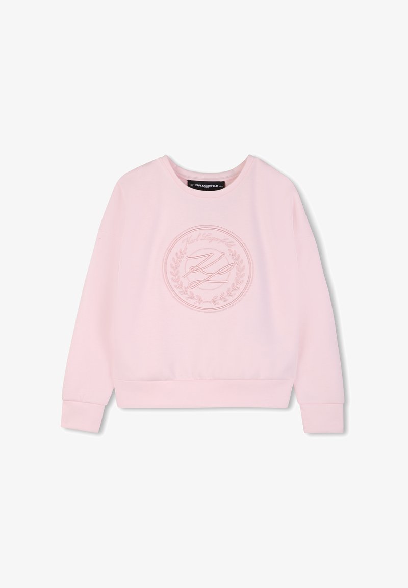 Sweatshirt rose clair en tissu doux, avec un logo rond brodé d'une couronne de laurier au centre, et des poignets et un ourlet côtelés.