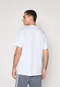 Hvid bomulds t-shirt med korte ærmer og rund halsudskæring, der har en afslappet pasform og et enkelt, udekoreret design.