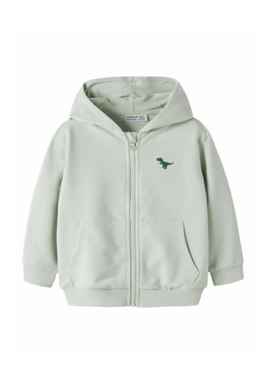 Sweat à capuche zippé gris clair pour enfants avec poches avant, une capuche et un petit motif de dinosaure vert foncé sur le côté gauche de la poitrine.