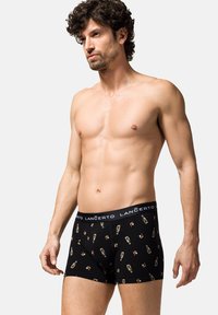 Czarne bokserki z grafikami różnych butelek na napoje, wykonane z elastycznego materiału z elastycznym paskiem w talii z logo marki.