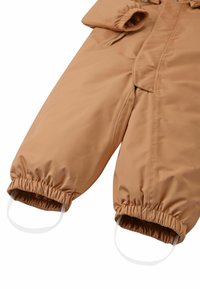 Monoski acolchado marrón con puños elásticos y correas para los pies integradas. Tejido liso y resistente al agua; cremallera frontal y cuello ajustable.