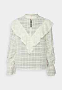 Blusa branca xadrez com gola frisada, costas em forma de buraco de chave e acabamento em renda ao longo das bordas. Mangas longas e ligeiramente bufantes. Tecido texturizado.