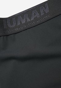 Tissu noir à la texture lisse, comportant une large ceinture avec "IUMAN" embossé en lettres foncées. Dans l'ensemble, un design élégant et minimaliste.