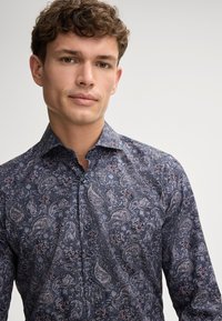 Hemd mit Knopfleiste in Dunkelblau mit Paisleymuster. Weicher Stoff, aufwendige Blumen- und Paisleymuster in helleren und gedämpften Farben.
