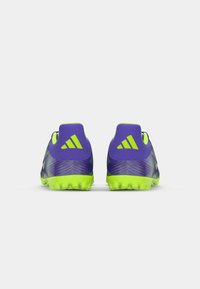 Purple football boots with textured design, green accents, and a molded sole with studs for traction. Features three-stripe logo.