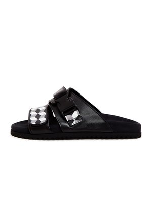 Sandală neagră cu talpă plată, având două curele ajustabile, material lucios, accente cu model geometric și o talpă texturată pentru aderență.