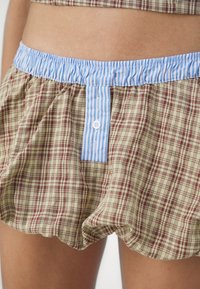 Brune og beige rutete shorts med et blåstripet elastisk liv, med knappelukking og samlet stoff for en avslappet passform.