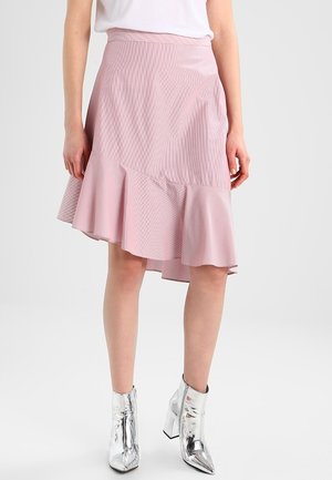 Jupe évasée rose avec un motif rayé léger, présentant un ourlet volanté et une finition lisse. Assortie à des bottines argentées brillantes.