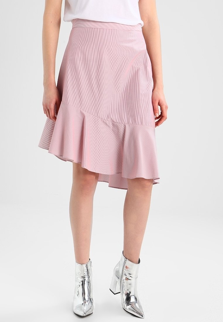 Jupe évasée rose avec un motif rayé léger, présentant un ourlet volanté et une finition lisse. Assortie à des bottines argentées brillantes.