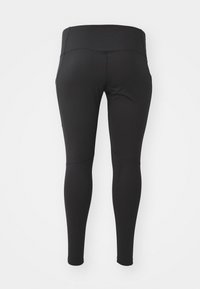 Leggings noirs en matériau extensible, dotés d'une taille haute, d'une coupe ajustée et d'une texture lisse. Aucune motif ou accent visible.
