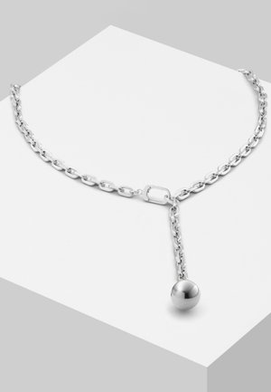 Collier en chaîne argentée présentant un pendentif sphérique lisse suspendu à une chaîne pendante. Les maillons sont de forme ovale et s'entrelacent.