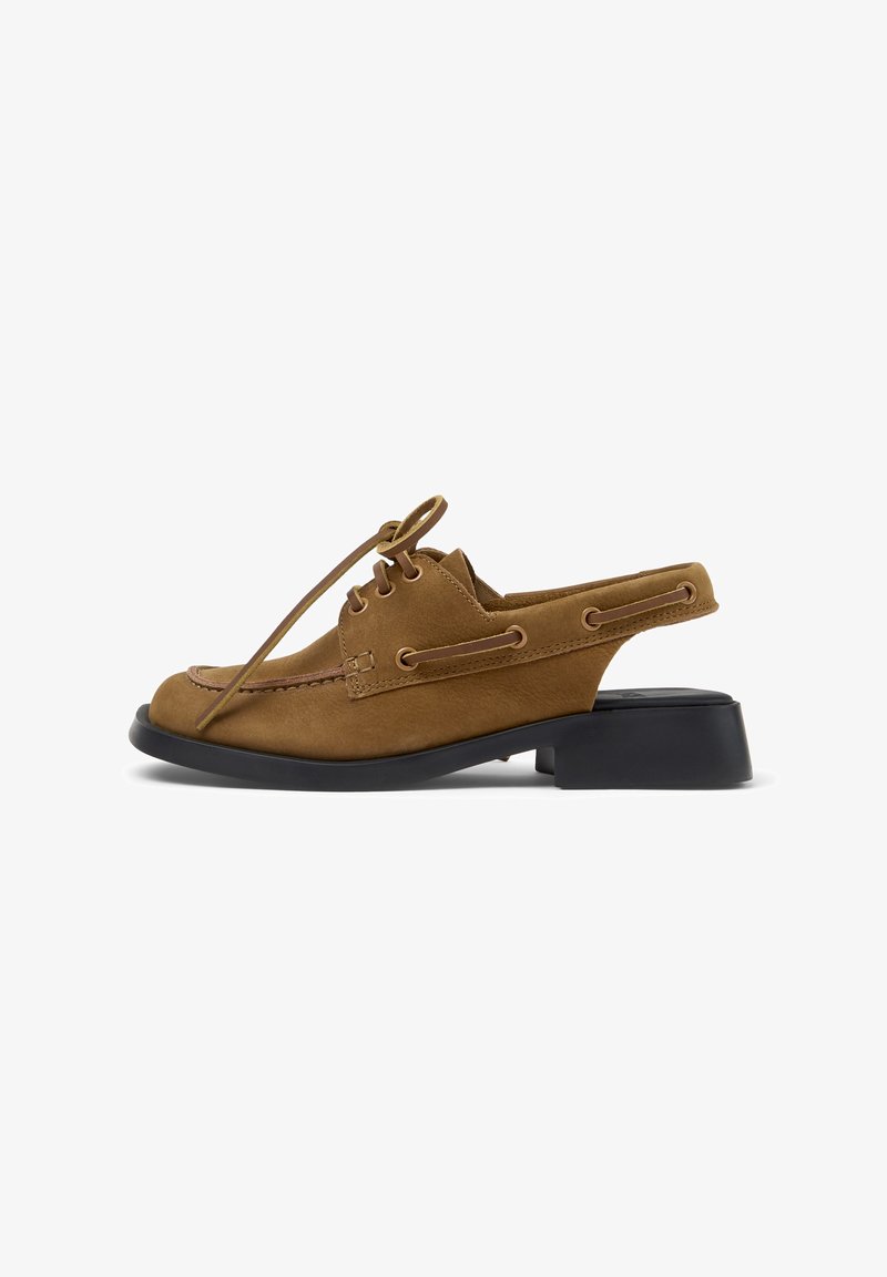 Brun lær slingback loafer med snøring foran, moc-tå-søm og svart lav blokkhel mot hvit bakgrunn.