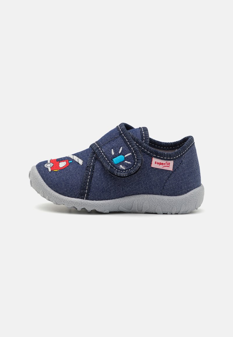 Blaue Stoffschlappen mit einem Klettverschluss, grauer Gummisohle und gestickten Cartoon-Details, darunter ein rotes Fahrzeug und ein Licht.