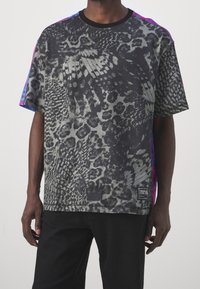 Svart t-shirt med kort ärm, prydd med abstrakta grå och svarta mönster, med rosa och blå detaljer på axlarna och en logotypetikett.