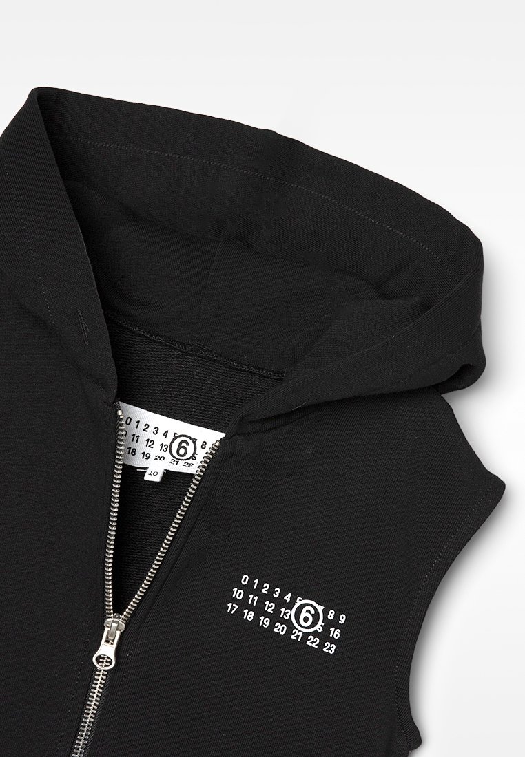 Czarna bezrękawnik z zamkiem błyskawicznym, z białym logotypem numerycznym "6" na piersi oraz metką wewnętrzną, wyeksponowany na białym tle.