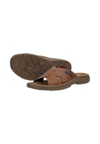 Bruine leren slippers met kruislings banden en textuur rubberen zolen, gepositioneerd met één slipper plat en de andere zool naar boven gericht.