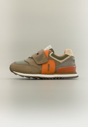 Barns brun og grønne sneaker med orange accenter og velcrolukning, vist i sideprofil på en neutral baggrund.