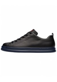 Sneaker in pelle nera con finitura liscia, punta arrotondata e suola in gomma blu. Presenta lacci arrotondati e un'etichetta sul tallone.