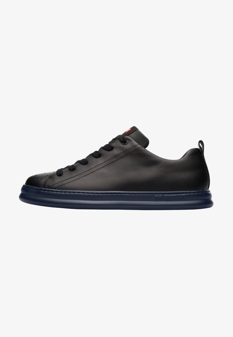 Sneaker in pelle nera con finitura liscia, punta arrotondata e suola in gomma blu. Presenta lacci arrotondati e un'etichetta sul tallone.