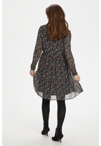 Czarna sukienka w kwiaty z długimi przezroczystymi rękawami, zebranym w pasie i zwiewnym dołem. Posiada kolorowe wzory na ciemnym tle.