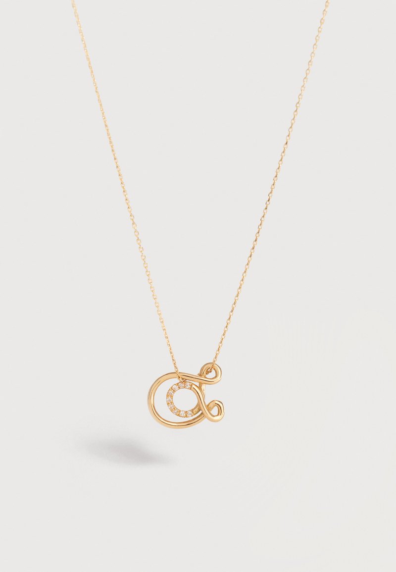 Gold chain necklace with a gold, looped pendant featuring a small circle of embedded diamonds in the center.