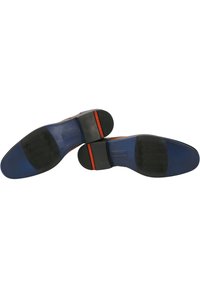 Semelles de chaussures en cuir, avec une finition brune lisse, un talon en caoutchouc noir, une bande d'accent rouge et un motif de grip texturé noir.