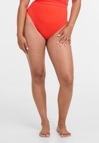Rote hochgeschnittene Bikinihosen mit glatter Textur und einem Design für umfassende Abdeckung, das eine klassische Form und saubere Kanten aufweist.
