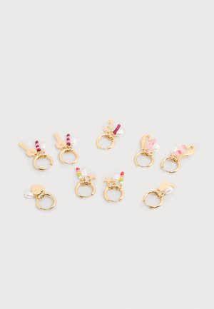 Huit boucles d'oreilles créoles en or avec des perles colorées, des perles de culture et de petits charms comprenant des clés, des étoiles, des cœurs et des plumes sur un fond blanc.