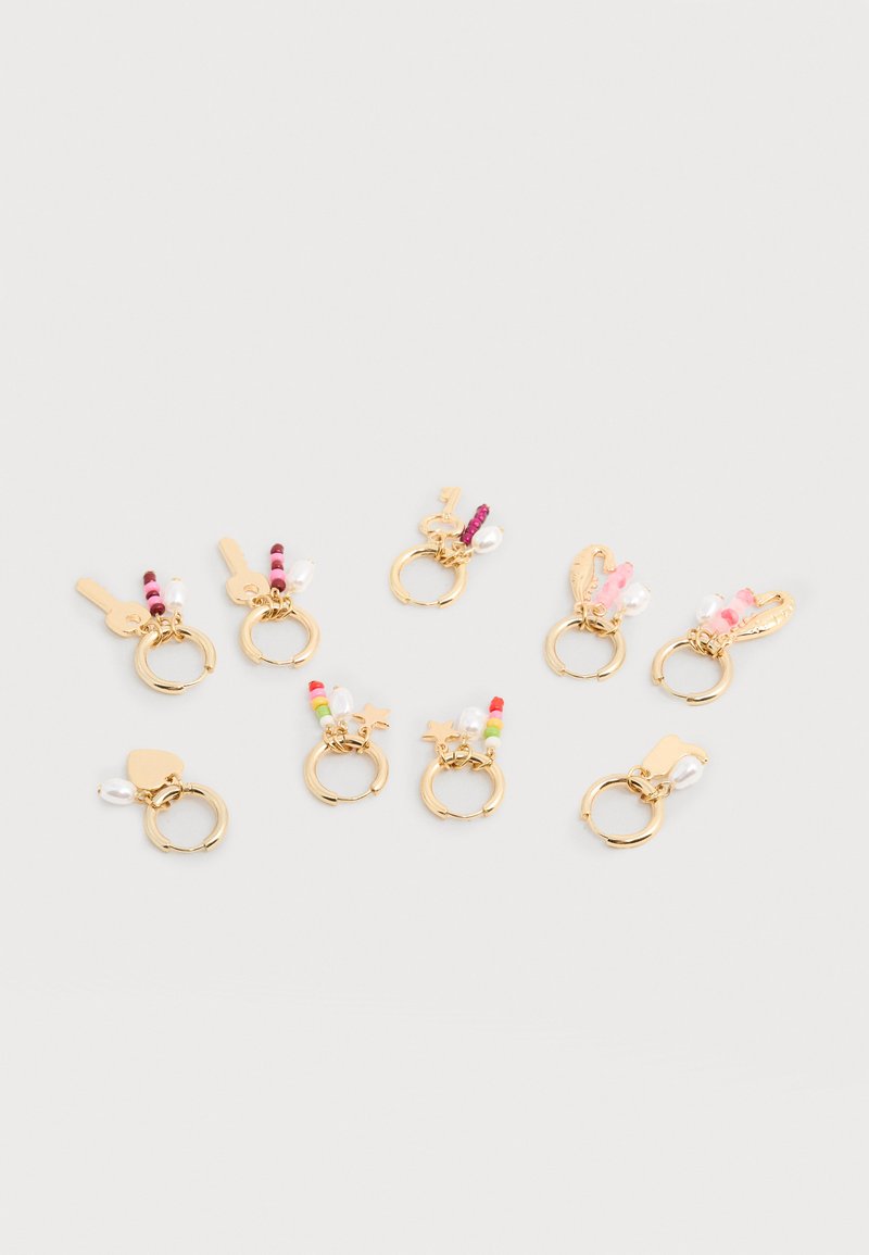 Οκτώ χρυσά σκουλαρίκια κρίκοι με πολύχρωμες χάντρες, πέρλες και μικρά γούρια, όπως κλειδιά, αστέρια, καρδιές και φτερά, σε λευκό φόντο.