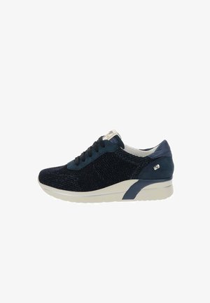 Zapatilla deportiva azul marino para mujer con parte superior de tela de punto, cordones negros, suela acolchada blanca y logotipo metálico sutil en el lateral del talón.