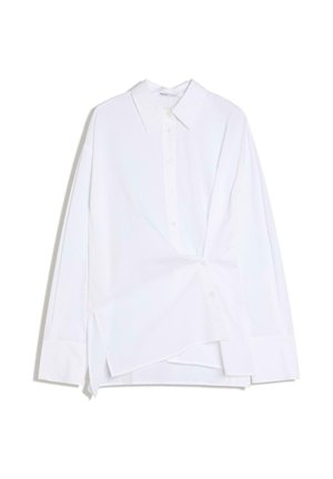 Bílá košile s dlouhým rukávem, zapínáním na knoflíky, s asymetrickým předním záhybem a klasickým límečkem, zobrazena na bílém pozadí.