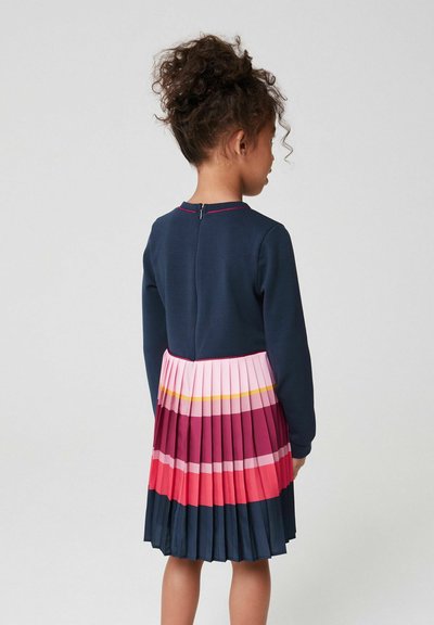 Abito a maniche lunghe di colore blu navy con gonna plissettata, disponibile in colori: blu scuro, rosa, rosso e strisce gialle. Dettaglio con zip sul retro vicino al collo.
