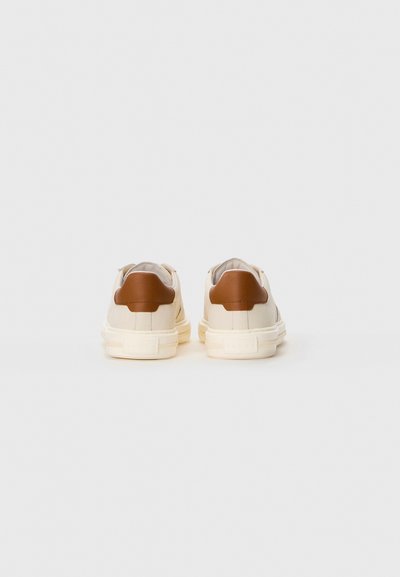 Pair of off-white sneakers with tan heel patches, viewed from the back on a plain white background.
