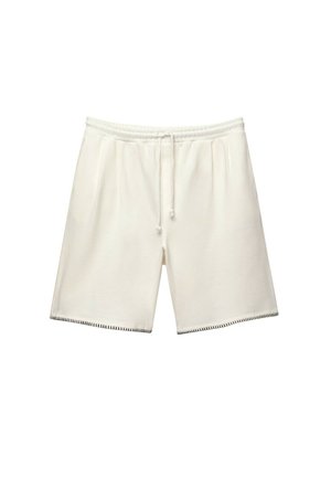 Pantaloni corti bianchi con vita elasticizzata e coulisse. Presentano tasche laterali e cuciture a contrasto lungo l'orlo. Tessuto morbido con texture liscia.