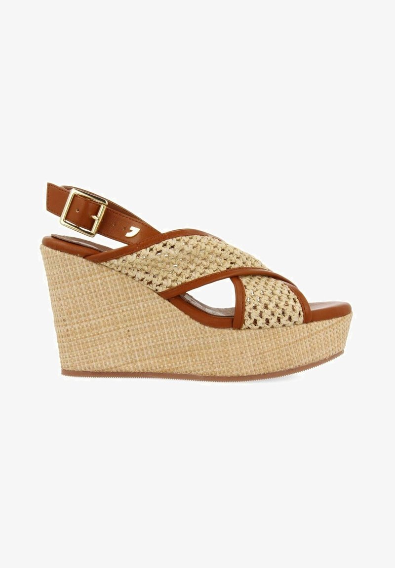 Sandale compensée avec une haute plateforme tissée, garniture en cuir marron, design à brides croisées et fermeture réglable à la cheville avec boucle.