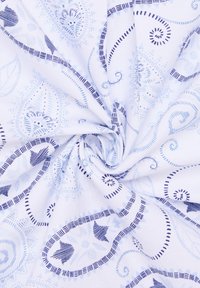 Tessuto di cotone bianco con intricati motivi a paisley e floreali in blu. Caratterizza design vorticosi e dettagli testurizzati.