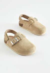 Chaussures en daim tan avec un bout arrondi, une sangle à la cheville et un accent en boucle argentée. Dotées d'une semelle texturée pour plus de grip.