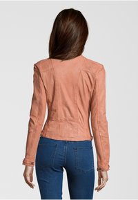 Giacca in pelle pesca con design aderente, cuciture dettagliate e maniche lunghe. Caratterizzata da una texture liscia e sottili accenti a pannelli.